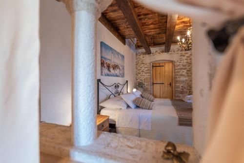 a bedroom with a bed and a stone wall at Villa Gland in Nin
