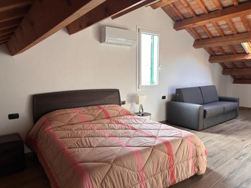 ein Schlafzimmer mit einem Bett und einem Stuhl in der Unterkunft IL FENICOTTERO in Comacchio