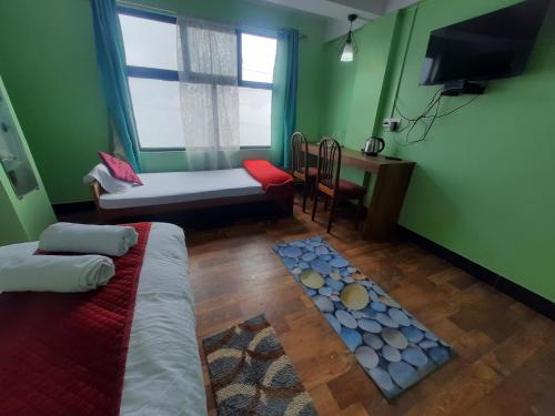 een kamer met 2 bedden, een tafel en een raam bij Bubble Beds in Darjeeling