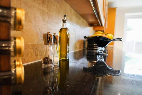 a kitchen counter with a bottle and a bowl of bananas at Luxury 4-bed in Oxford with 2x parking & garden in Oxford