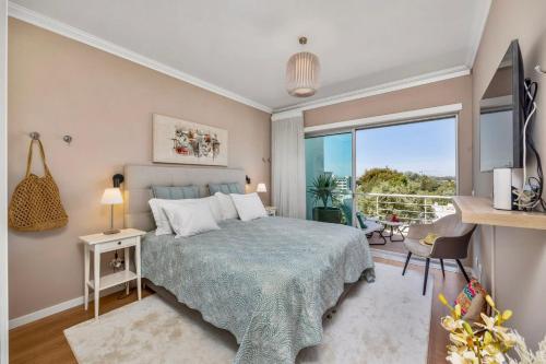 a bedroom with a bed and a large window at Luxury Villa in Serene Location with Pool & Private Garden in Quarteira