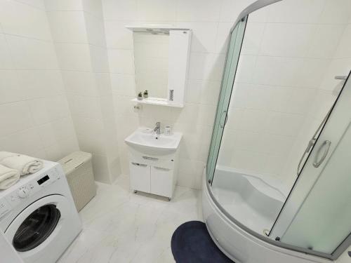 a bathroom with a shower sink and a washing machine at Central Exclusive Ap4you.if in Ivano-Frankivsʼk