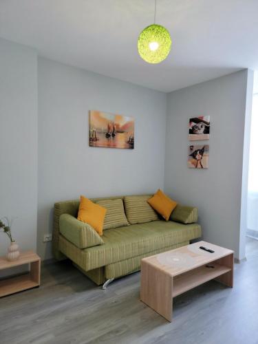 a living room with a green couch and a table at Central Exclusive Ap4you.if in Ivano-Frankivsʼk