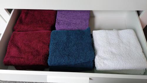 a white drawer filled with different colored towels at Holiday Home Achterbos in Sint-Oedenrode