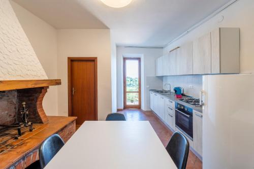 a kitchen with a white table and a refrigerator at Le Vecchie Cantine in Chianni