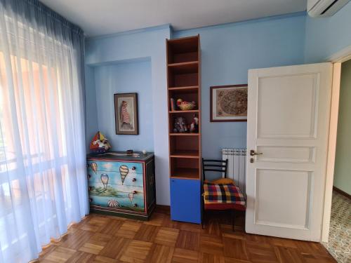 a blue room with a book shelf and a door at Grande Attico con Vista Vicino al Centro by PortofinoVacanze in Rapallo