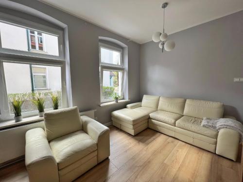 a living room with two couches and two windows at Apartament Olivia Business Suite in Gdańsk