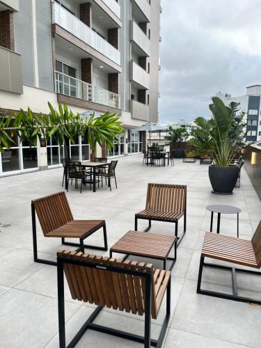 a patio with benches and tables on a building at Hub Home - Vista Incrível in Criciúma