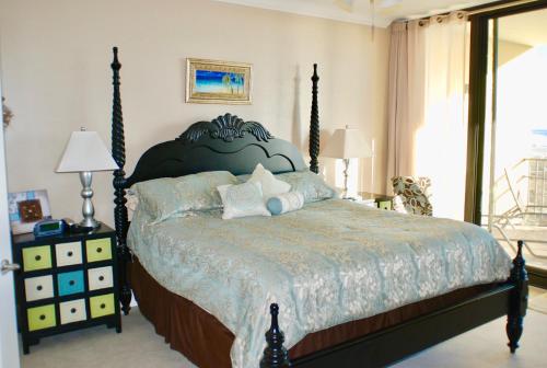 a bedroom with a large bed with a blue bedspread at Holiday Isle 412 in Dauphin Island