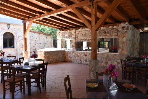 a restaurant with tables and chairs and a kitchen at Boutique Hotel Tilos Mare in Livadia
