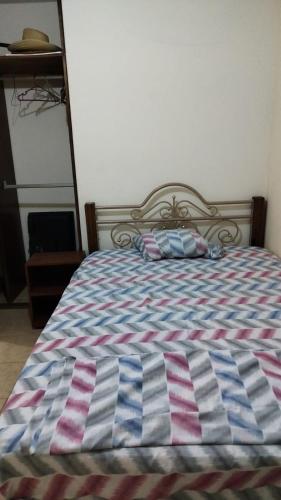 Bett mit gestreifter Decke in der Unterkunft Habitacion privada in Tehuacán