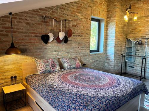 a bedroom with a bed and a brick wall at Magic Attic in Historical House in Tbilisi City