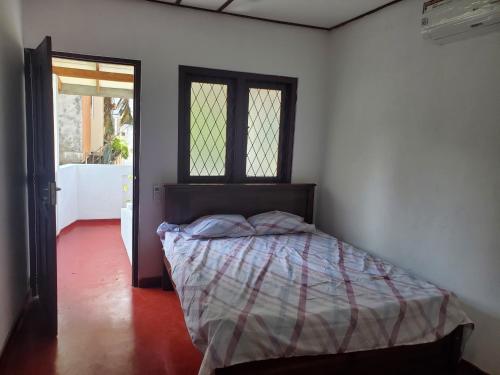 a bedroom with a bed in a room with a window at Mount lavinia home in Watumulla