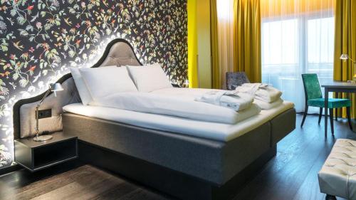 a bedroom with a bed with a wall with flowers at Thon Hotel Bergen Airport in Bergen