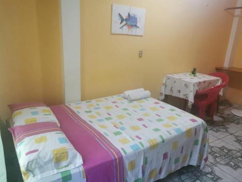 1 dormitorio con 1 cama y 1 mesa con en Mark’s home, en Puerto Ayora