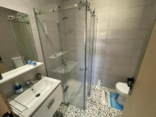 a bathroom with a shower and a sink and a toilet at Good Life Yellow and Ocean Holiday Apartments in Taoutiet el Bioute