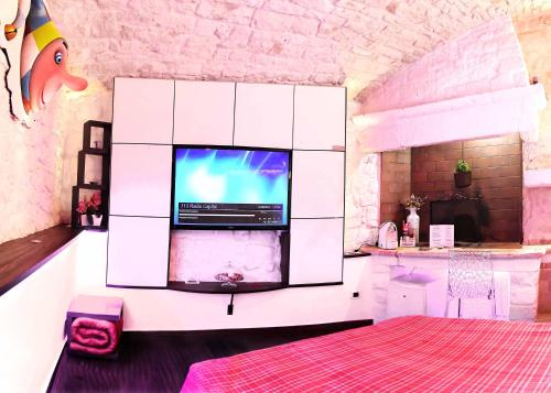 a kitchen with a tv in a white cabinet at l'angolo di Gaudì, alcoba Capriccio in Putignano