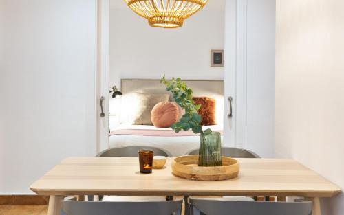 a table and chairs with a bed in the background at Columbus Apartment in Barcelona