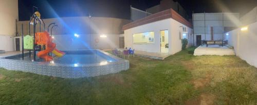 un modello di casa con parco giochi in cortile di استراحة بغرفة نوم ومسبح ألعاب مائيه a Ḩarāḑah
