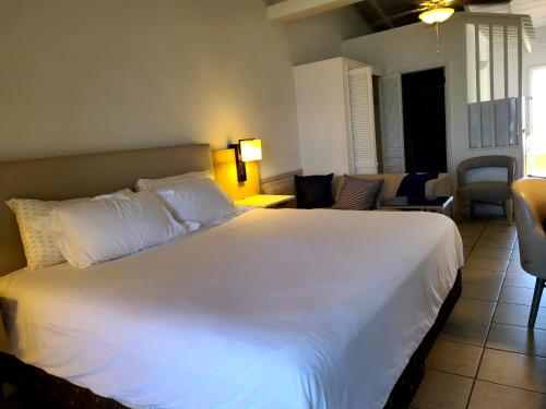 a bedroom with a large white bed and a living room at Boundless Bliss Hotel in St Thomas