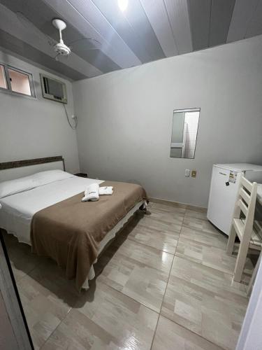 a bedroom with a bed and a table in it at Vista Oceanica Pousada in Marataizes