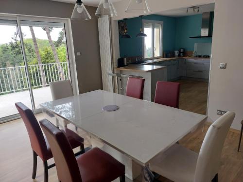 une cuisine et une salle à manger avec une table et des chaises blanches dans l'établissement Les Jardins de la Béné, à Fécamp