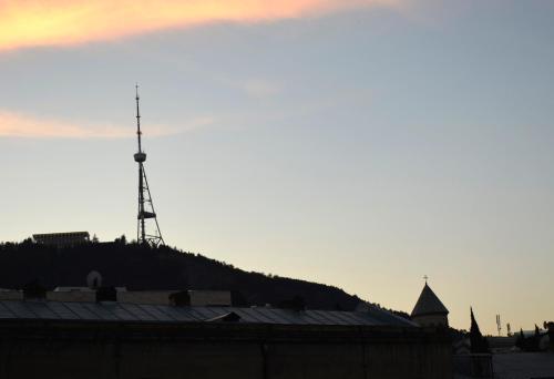a windmill on top of a hill with a building at Magic Attic in Historical House in Tbilisi City
