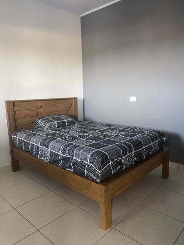 ein Bett mit einer schwarzen und weißen Bettdecke in einem Zimmer in der Unterkunft Casa de temporada Stracini in Taquaritinga