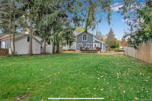 a blue house with a yard with a fence at Chair Lift Lodge- Best Location in EVL Village! in Ellicottville