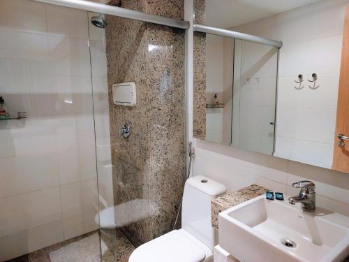 a bathroom with a toilet and a sink and a shower at Flat Cullinan Brasília SL in Brasilia