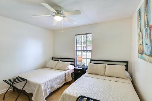 two beds in a room with a ceiling fan at Bright Tallahassee Vacation Rental Near FSU and FAMU in Tallahassee