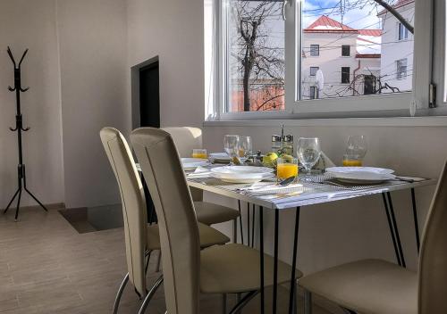 a dining room table with chairs and a window at Центр посуточно Новая двухуровневая квартира da Luisa in Mukacheve