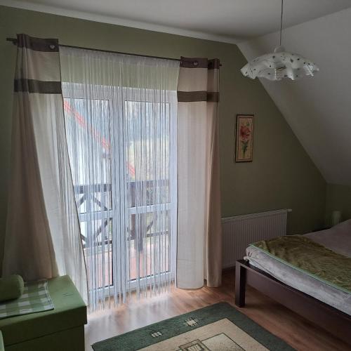 a bedroom with a large window and a bed at Domki Oaza Spokoju Berezka in Berezka