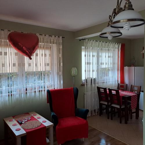 a living room with a red chair and a table at Domki Oaza Spokoju Berezka in Berezka