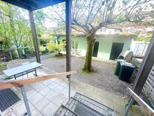 un porche cubierto con una mesa de picnic y un árbol en Cozy 1 room apartment in Zug, en Zug