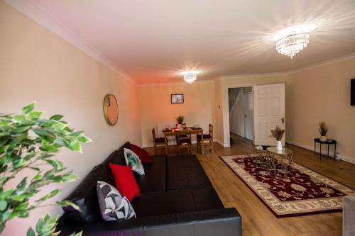 a living room with a couch and a table at Spacious London Home - Garden, BBQ & Free Parking, Sleeps 8 in London
