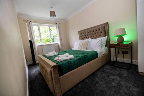 a bedroom with a bed with two towels on it at Spacious London Home - Garden, BBQ & Free Parking, Sleeps 8 in London