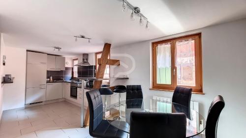 une cuisine et une salle à manger avec une table et des chaises en verre dans l'établissement Le Zen d'Eguisheim, à Eguisheim