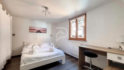een slaapkamer met een bed, een bureau en een raam bij Le Zen d'Eguisheim in Eguisheim