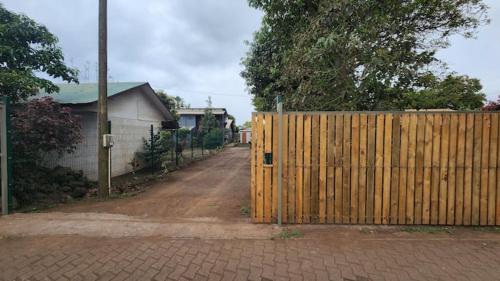 a wooden gate on a dirt road next to a house at marari rapa nui in Hanga Roa