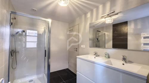baño blanco con ducha y lavamanos en Le Zen d'Eguisheim, en Eguisheim