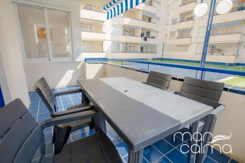 una mesa y sillas en un balcón con piscina en Apartamento Miramar by MarCalma, en Torredembarra