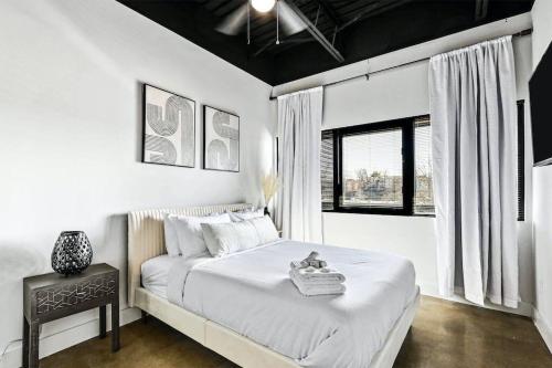 a white bedroom with a bed and a window at Brand New Condo near downtown Nash w washer dryer in Nashville