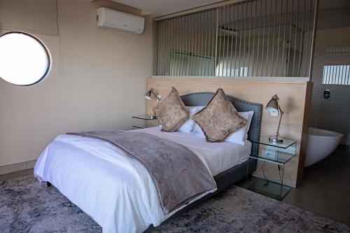a bedroom with a bed and a bath tub and a bed sidx sidx sidx sidx at 7 on Marine in Hermanus