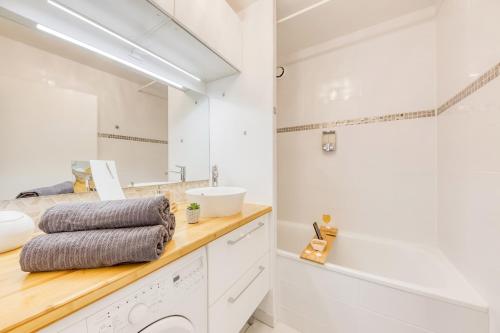 une salle de bain blanche avec un lavabo et un miroir dans l'établissement DisneyLand Paris Station 2min, à Chessy