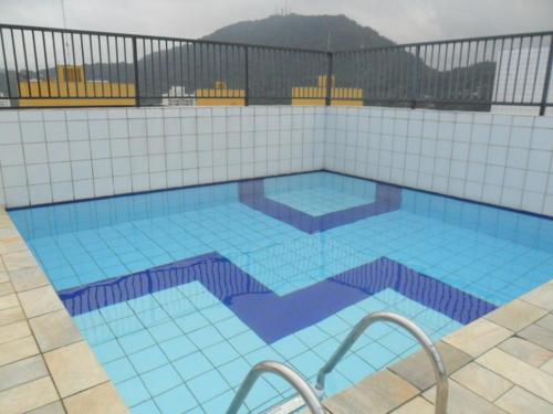 a large swimming pool with blue tiles on a building at Dom Pedro 26 in Guarujá