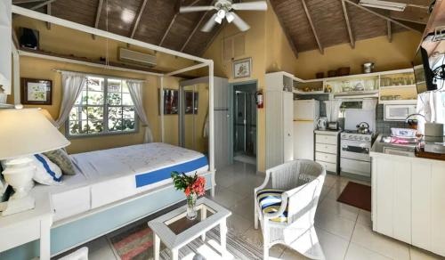 a bedroom with a large bed and a kitchen at Goat Hill & Goat Rock Studios in Cobbs Cross