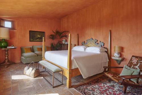 a bedroom with a king sized bed and a couch at Castello Di Vicarello in Sasso dʼOmbrone