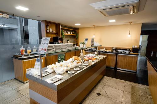 a kitchen with a counter with dishes on it at Nobile Suites Diamond in Vitória