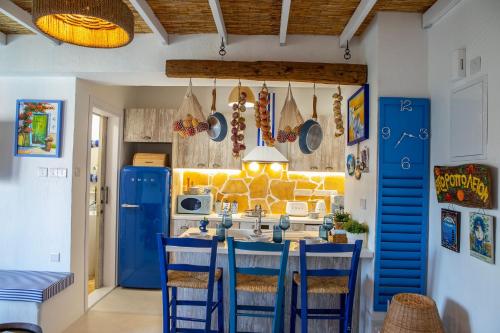 a kitchen with blue chairs and a table with a microwave at Castle Holiday Apartments in Limassol